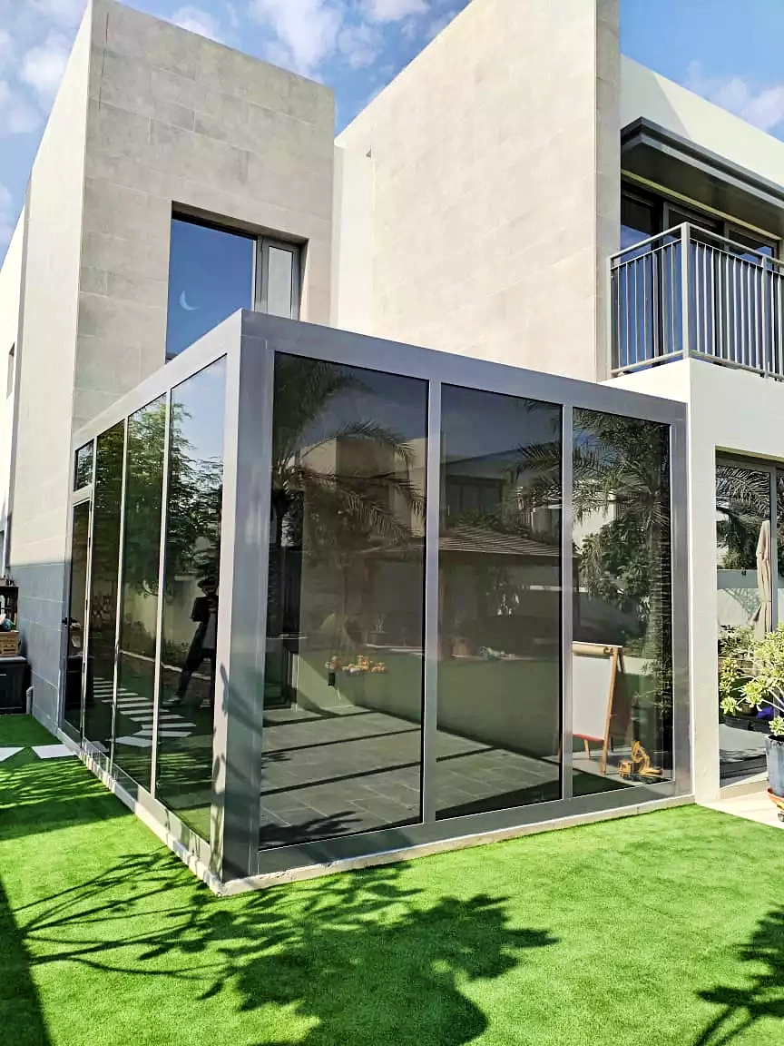 A spacious and bright glassroom overlooking a garden.