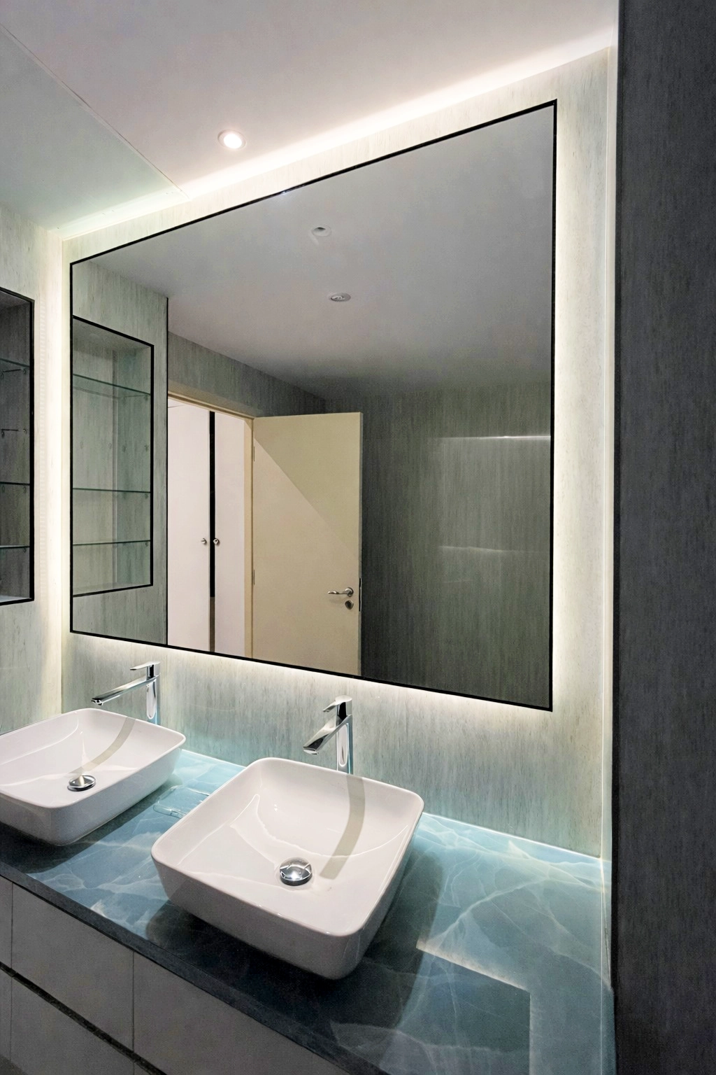 A modern bathroom with a backlit mirror.